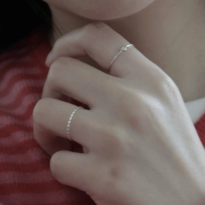 Detail of 925 sterling silver beaded and twisted knot rings stacked on a hand