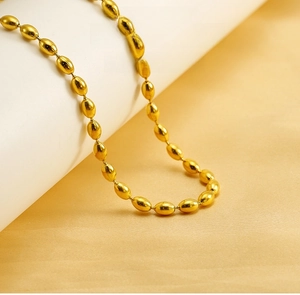 Detailed view of polished golden oval bead necklace with high-gloss metallic finish