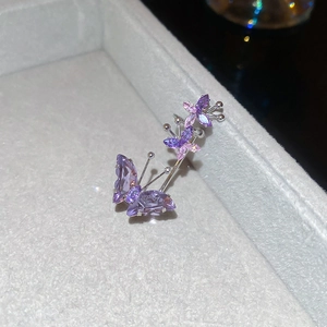 Macro shot of purple cubic zirconia butterfly ear cuff with shimmering silver metallic finish