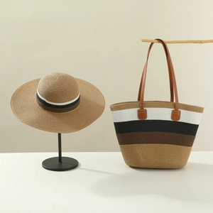 Detail of color-block striped straw tote bag and matching wide-brim sun hat on display
