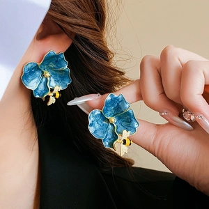 Detailed close-up of vintage flower earrings with blue enamel petals and bee accents