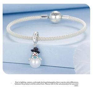 Silver snowman charm with blue scarf on a textured snake chain bracelet with feathers