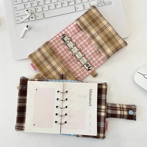 Detail of yellow and brown plaid fabric journal covers with a six-ring metal binder system