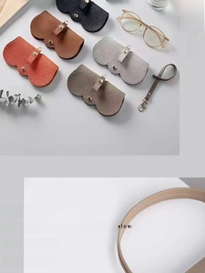 Détail d'étuis à lunettes en cuir grainé avec d'élégantes fermetures à pression dorées