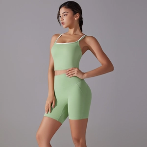 Detail of mint green yoga set featuring white piping and crossover back sports top