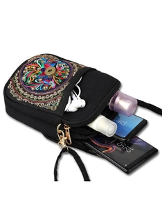 Detail of compact ethnic crossbody bag showing interior storage capacity for phones