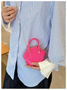 Pink mini jelly shell bag with quilted texture and gold chain strap shown on model