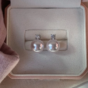 Detailed view of pearl earrings with diamonds in a luxury velvet gift box