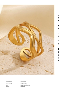 Detailed view of wave-shaped 18K gold-plated stainless steel ring on textured stone