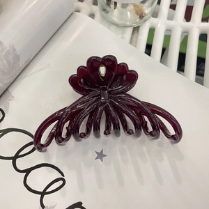 Detail view of large burgundy butterfly hair claw clip with glossy finish for styling
