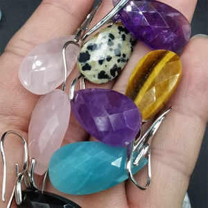 Macro shot of assorted faceted teardrop gemstone earrings including amethyst and quartz