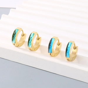 Detail of minimalist titanium steel earrings with emerald and navy blue crystals
