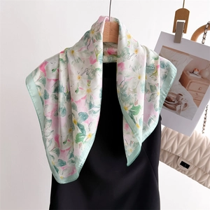 Élégant carré en soie aux motifs floraux roses et verts sur un cintre en bois