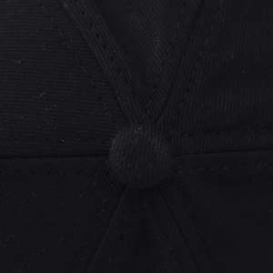 Gros plan du haut de la casquette noire en coton montrant le bouton et les coutures renforcées