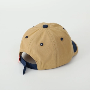 Detail of adjustable back strap and navy contrast stitching on a khaki baby baseball cap