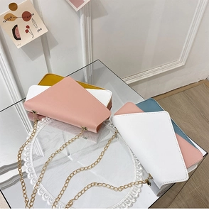Detail view of colorful PU leather crossbody bags with metal chains and geometric flaps