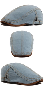 Close-up of contrast stitching on denim flat cap with adjustable bronze metal side buckle