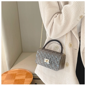 Detail of grey quilted jelly bag with black beaded handle and gold chain strap