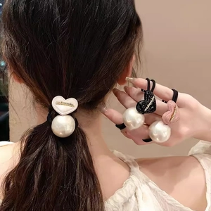 Détail d'élastiques à cheveux avec perles et breloques en forme de cœur coloré