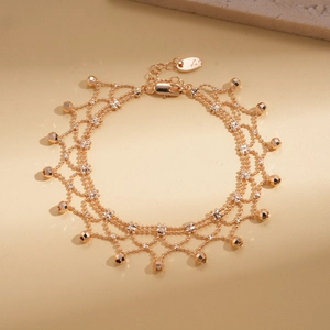 Detailed view of layered rose gold bracelet with lace weaving and multifaceted beads