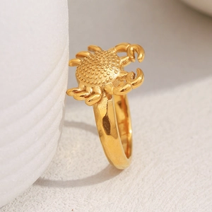 Macro shot of gold crab ring detailing 18K gold plating and embossed texture