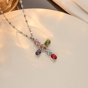 Detail of cross pendant featuring six colorful oval gemstones and cubic zirconia accents
