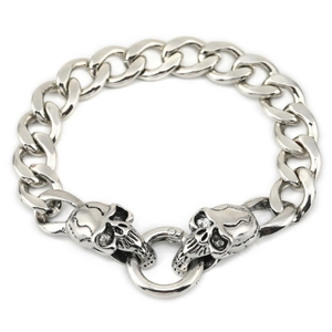 Close-up of vintage silver skull charm links on a heavy punk style metal chain bracelet