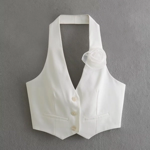 Detail of white halter vest featuring 3-button closure and delicate 3D floral mesh applique