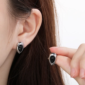 Vue détaillée des boucles d'oreilles goutte argentées avec pierre œil de chat noire