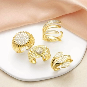 Set of four gold plated open rings with cubic zirconia on elegant pink silk fabric