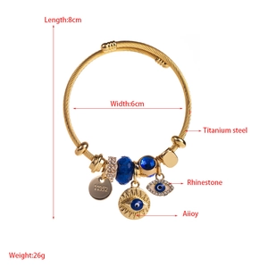 Detailed view of titanium steel charm bracelet with evil eye pendants and rhinestone beads