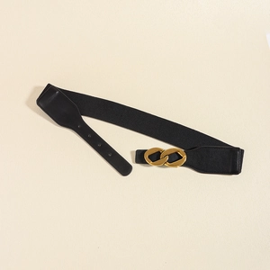 Close-up of black elastic waist belt with interlocking gold buckle and faux leather finish
