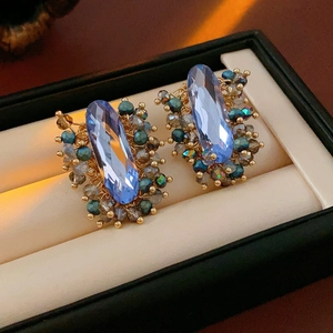 Makroaufnahme von Vintage-Ohrringen mit blauem Kristall und bunter Perlen-Drahtwicklung