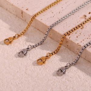 Detailed close-up of 18K gold and silver stainless steel box chains with lobster clasps