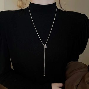Detail of adjustable silver Y-shaped sweater necklace with cubic zirconia and round beads