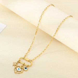 Close-up of gold chain necklace featuring enamel evil eye and rhinestone star charms