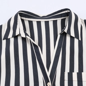 Close-up of black and white vertical striped shirt collar and front chest pocket detail