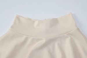Vue macro détaillée de la taille haute et de la texture en maille de cette robe beige