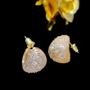 Macro shot of gold teardrop stud earrings with pavé set cubic zirconia and butterfly back