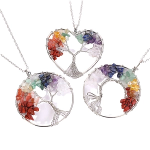 Natural crystal tree of life wire wrapped heart and round necklaces on white background