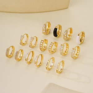 Golden earrings collection with zircon inlay and enamel details on beige background