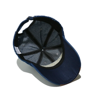 Detail view of the navy cotton denim baseball cap interior with adjustable strap