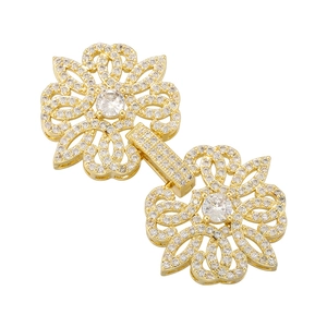 Detailed macro view of golden double-flower connector clasp with inlaid white cubic zirconia