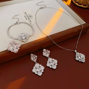 Détail d'une parure florale argentée avec zircons sur un fond en textile blanc