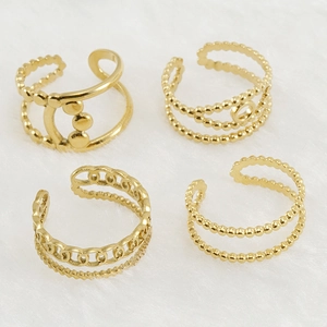 Flat lay of four adjustable 18K gold-plated stainless steel rings on white fur background