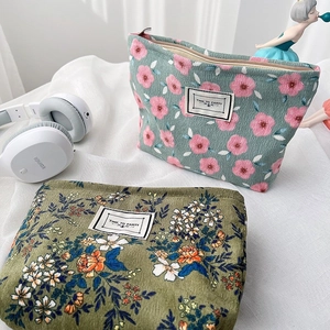 Floral corduroy makeup bags with Time to Party tags and zippers on a soft white fabric