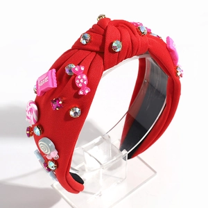 Macro shot of red fabric knotted headband with colorful candies and shiny rhinestones