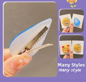 Dettaglio delle mollette goccia d'acqua blu e vari accessori per capelli stile Emoji