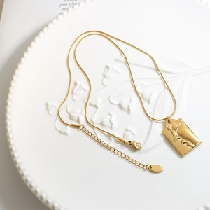 Minimalistische goldene Schlangenkette mit abstraktem Gesicht-Relief-Porträt-Anhänger