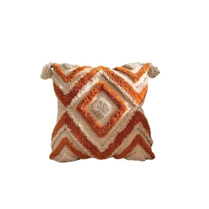 Bohemian tufted cushion cover with orange geometric patterns and tassels on white background
